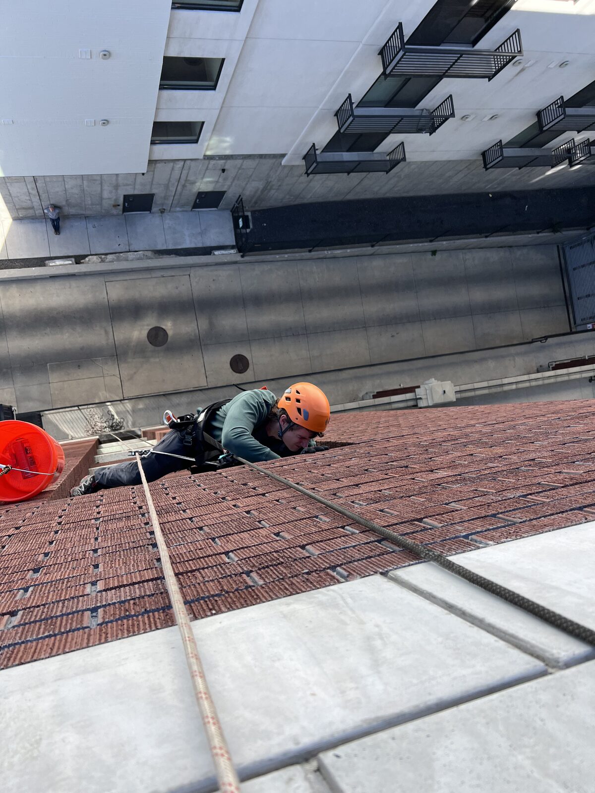 Rope-access technician inspecting a brick commercial building